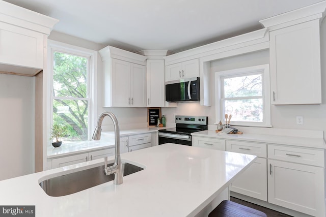 267 S 12th St, Lebanon, PA 17042 - kitchen featuring stainless steel appliances, a sink, white cabinets, light countertops, and plenty of natural light