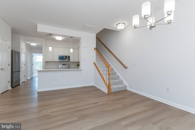 1859 Cedar Cove Way Unit 201, Woodbridge, VA 22191 - kitchen with appliances with stainless steel finishes, a chandelier, light wood-type flooring, and white cabinets