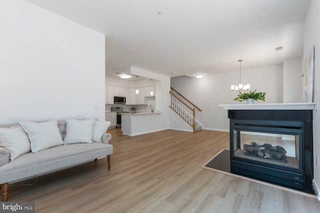 1859 Cedar Cove Way Unit 201, Woodbridge, VA 22191 - living area featuring light wood-style floors, a chandelier, stairs, and baseboards