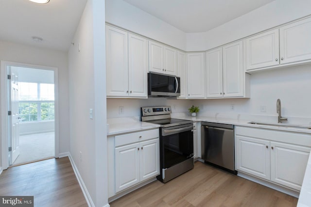 1859 Cedar Cove Way Unit 201, Woodbridge, VA 22191 - kitchen featuring stainless steel appliances, a sink, light wood finished floors, white cabinets, and light countertops