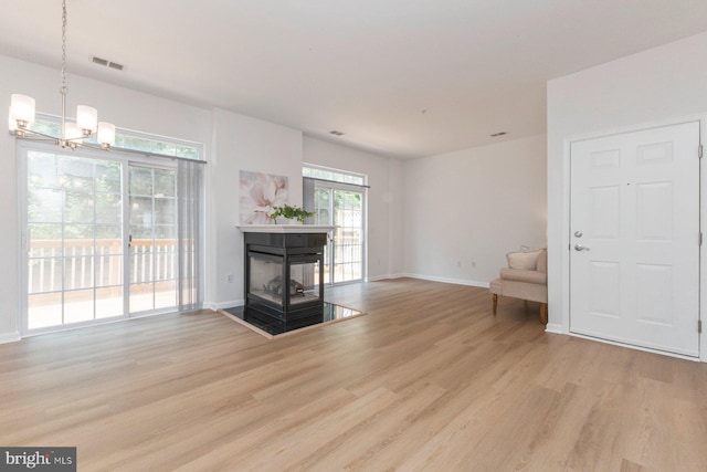 1859 Cedar Cove Way Unit 201, Woodbridge, VA 22191 - unfurnished living room with light wood-style flooring, a chandelier, baseboards, and a multi sided fireplace