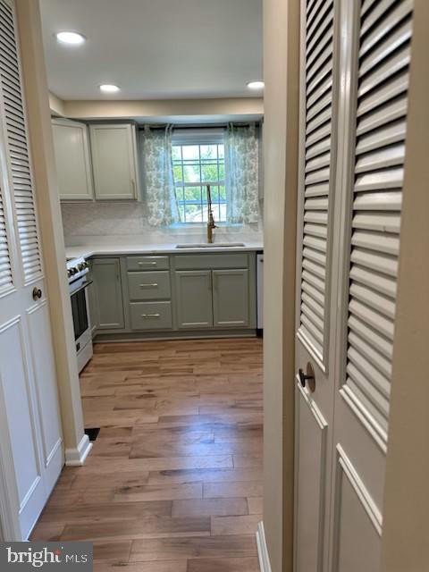 475 Ruffian Ct, Annapolis, MD 21409 - kitchen with a sink, stainless steel stove, light wood-type flooring, light countertops, and recessed lighting