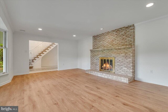 711 E Center St, Nesquehoning, PA 18240 - unfurnished living room featuring stairs, wood finished floors, a brick fireplace, ornamental molding, and recessed lighting