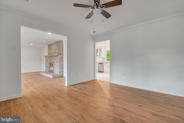 711 E Center St, Nesquehoning, PA 18240 - unfurnished living room with ceiling fan, ornamental molding, light wood-style floors, baseboards, and a brick fireplace