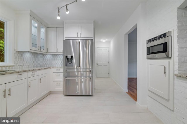 711 E Center St, Nesquehoning, PA 18240 - kitchen featuring stainless steel refrigerator with ice dispenser, white cabinets, tasteful backsplash, light stone countertops, and glass insert cabinets