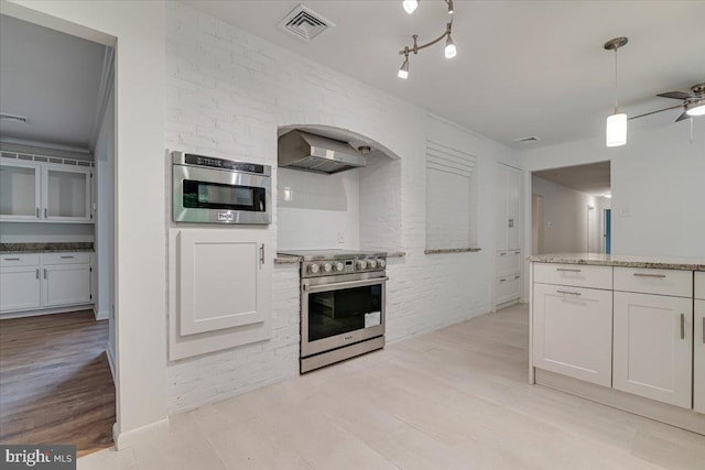 711 E Center St, Nesquehoning, PA 18240 - kitchen with stainless steel electric range oven, wall chimney range hood, light wood-style flooring, arched walkways, and light stone counters