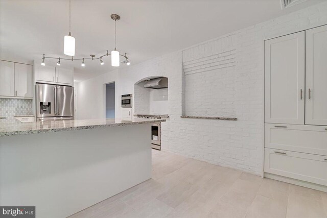 711 E Center St, Nesquehoning, PA 18240 - kitchen featuring stainless steel appliances, brick wall, white cabinets, light stone countertops, and wall chimney exhaust hood