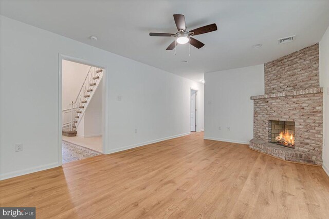 711 E Center St, Nesquehoning, PA 18240 - unfurnished living room with stairway, a ceiling fan, wood finished floors, and a brick fireplace