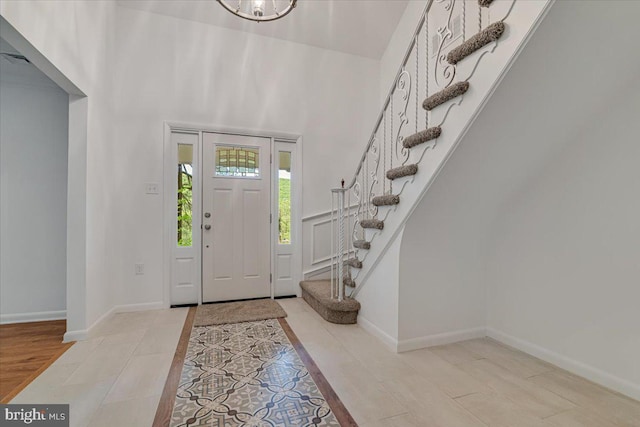 711 E Center St, Nesquehoning, PA 18240 - entryway with stairs, baseboards, a towering ceiling, tile patterned floors, and a chandelier