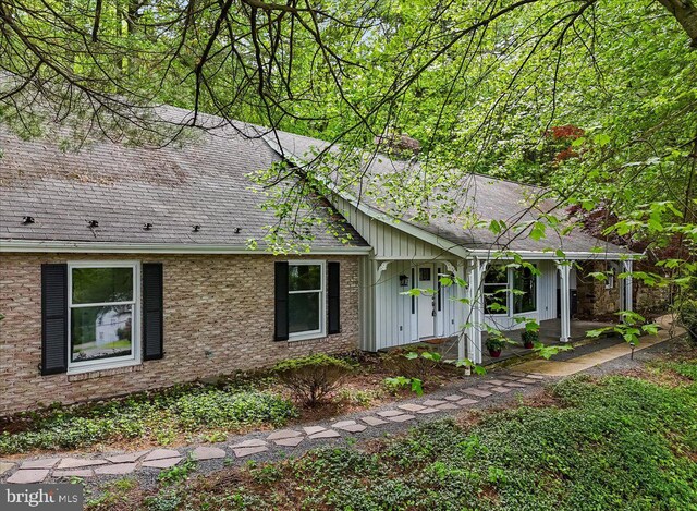 711 E Center St, Nesquehoning, PA 18240 - view of front of property featuring a shingled roof, brick siding, and board and batten siding