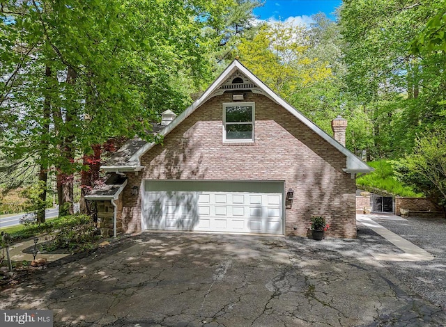 711 E Center St, Nesquehoning, PA 18240 - view of front facade with a chimney, asphalt driveway, a garage, and brick siding