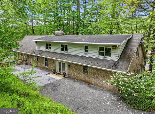 711 E Center St, Nesquehoning, PA 18240 - rear view of house with a patio area, a chimney, and a shingled roof