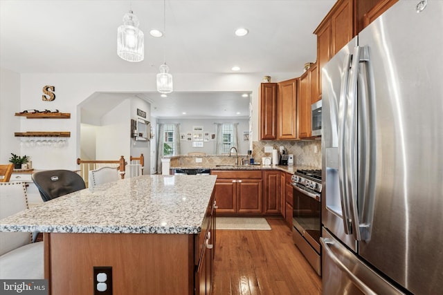 42 Mulberry Grn, Spring City, PA 19475 - kitchen featuring stainless steel appliances, brown cabinetry, light wood-style flooring, light stone counters, and recessed lighting