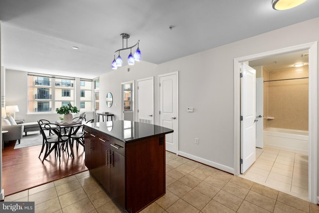157 Fleet St Unit 1006, Oxon Hill, MD 20745 - kitchen with light tile patterned floors, a center island, dark countertops, dark brown cabinets, and open floor plan