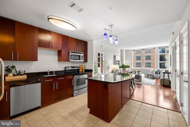 157 Fleet St Unit 1006, Oxon Hill, MD 20745 - kitchen with appliances with stainless steel finishes, dark countertops, open floor plan, a sink, and a center island