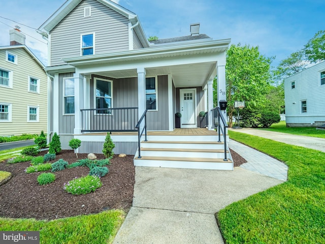 58 Park Ave, Hamilton, NJ 08690 - view of front of house featuring covered porch, board and batten siding, and a front yard