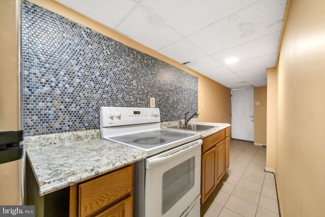 7252 Brent Rd, Upper Darby, PA 19082 - kitchen featuring white range with electric cooktop, a sink, a paneled ceiling, light tile patterned flooring, and decorative backsplash