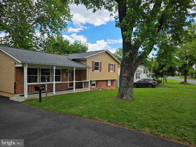 402 W Maple Ave, Sterling, VA 20164 - tri-level home with a front yard, brick siding, covered porch, and roof with shingles