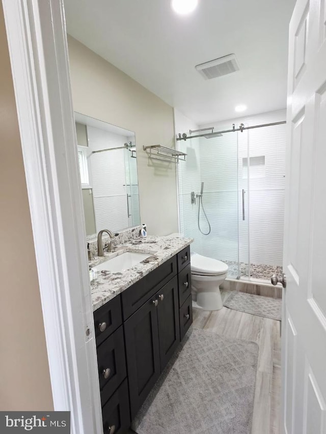 402 W Maple Ave, Sterling, VA 20164 - full bathroom with vanity, a stall shower, toilet, and wood finished floors