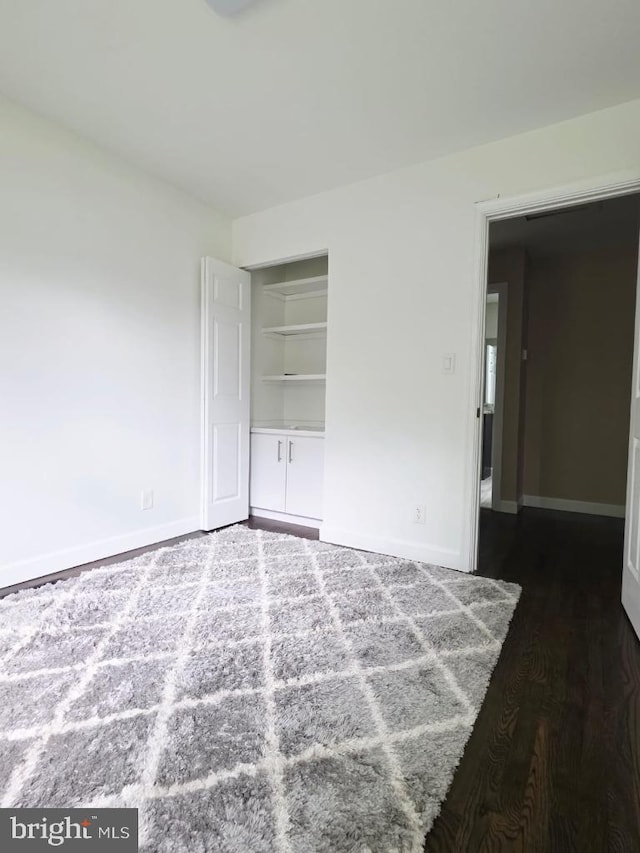 402 W Maple Ave, Sterling, VA 20164 - spare room featuring dark wood-style flooring, baseboards, and built in features