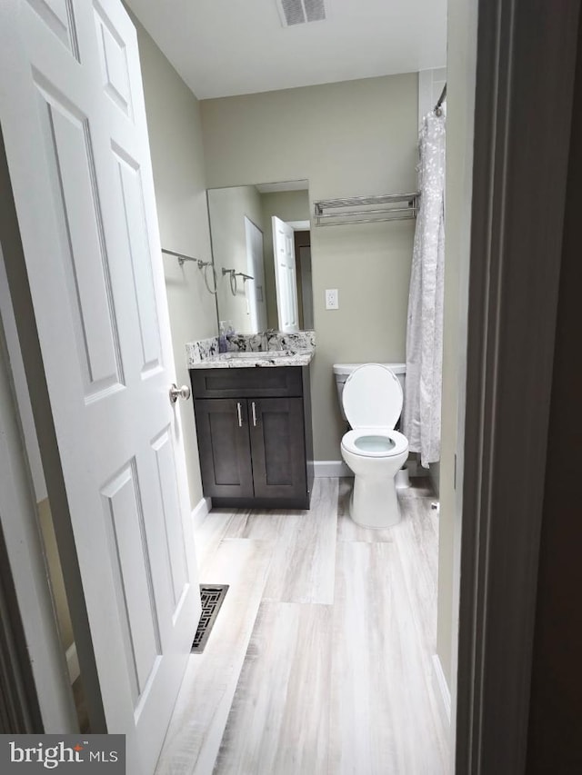402 W Maple Ave, Sterling, VA 20164 - bathroom featuring toilet, vanity, wood finished floors, and baseboards