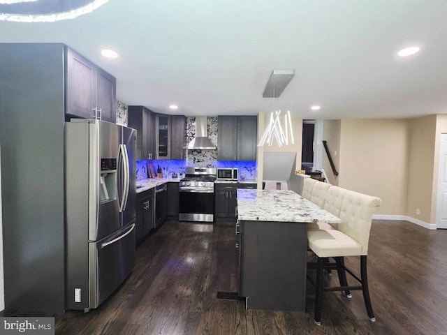 402 W Maple Ave, Sterling, VA 20164 - kitchen with appliances with stainless steel finishes, wall chimney exhaust hood, dark wood-style flooring, recessed lighting, and a breakfast bar area
