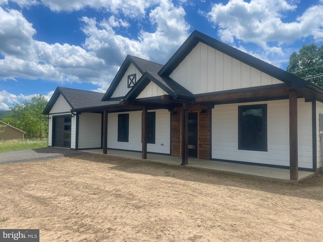 211 Workman Dr, Keyser, WV 26726 - view of front of house featuring an attached garage, dirt driveway, board and batten siding, covered porch, and roof with shingles