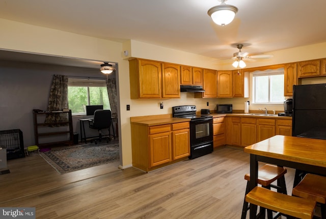 207 Coville Dr, Browns Mills, NJ 08015 - kitchen featuring black appliances, under cabinet range hood, a sink, ceiling fan, and light wood-style flooring
