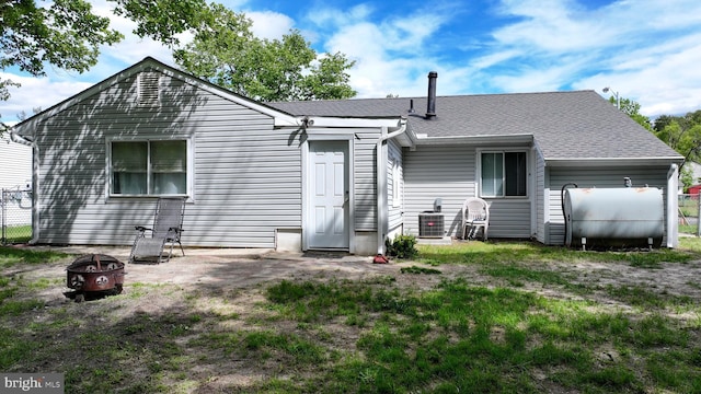 207 Coville Dr, Browns Mills, NJ 08015 - back of property with oil tank, a fire pit, central AC unit, and roof with shingles