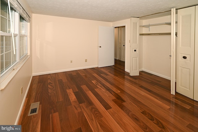 8110 Winter Blue Ct, Springfield, VA 22153 - unfurnished bedroom featuring dark wood-style flooring, baseboards, a textured ceiling, and two closets