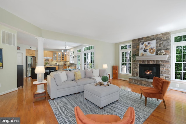850 Still Creek Ln, Gaithersburg, MD 20878 - living area with light wood finished floors, a fireplace, baseboards, and decorative columns