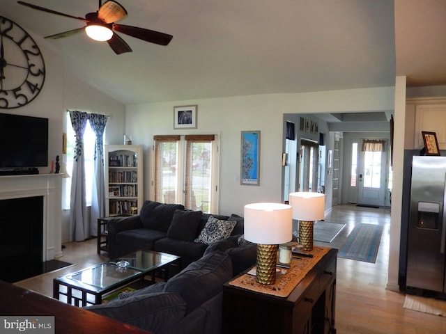 20172 Trap Pond Ct, Millville, DE 19967 - living room featuring a ceiling fan, light wood-style floors, vaulted ceiling, and a fireplace with flush hearth