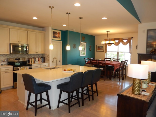 20172 Trap Pond Ct, Millville, DE 19967 - kitchen featuring stainless steel appliances, a sink, backsplash, light wood-style flooring, and light countertops