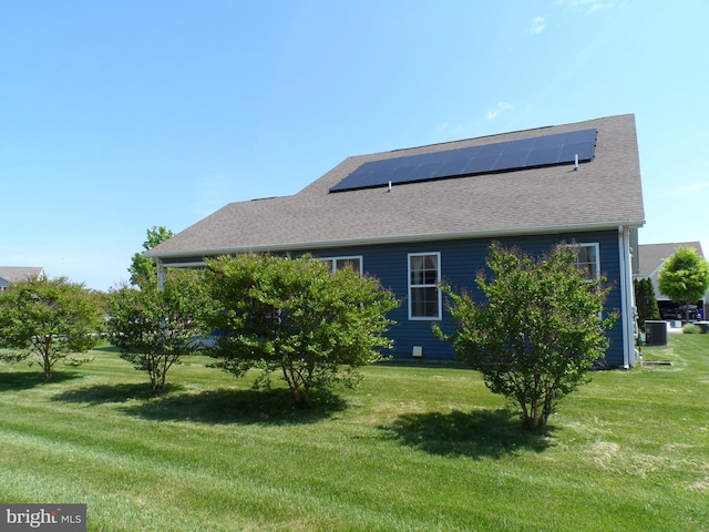 20172 Trap Pond Ct, Millville, DE 19967 - back of property with a lawn, central AC unit, solar panels, and roof with shingles