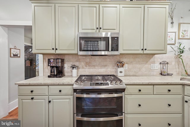 2 Broad St, Stockton, NJ 08559 - kitchen featuring appliances with stainless steel finishes, decorative backsplash, and cream cabinetry
