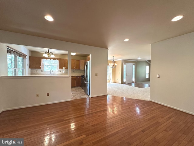448 Country Club Dr, Lansdale, PA 19446 - unfurnished living room featuring a chandelier, light wood-style floors, recessed lighting, baseboards, and a sink
