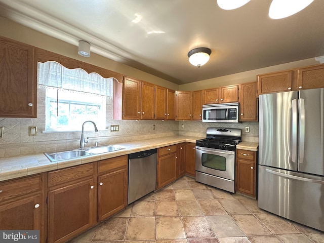 448 Country Club Dr, Lansdale, PA 19446 - kitchen featuring appliances with stainless steel finishes, a sink, brown cabinets, and tasteful backsplash