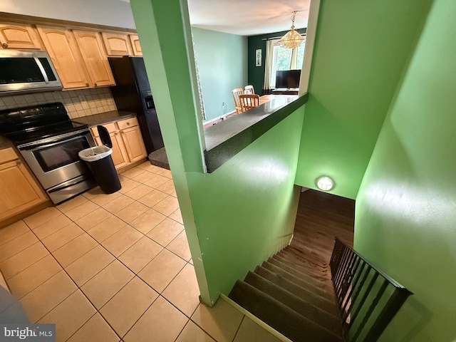 1236 Whittier Ave, Bensalem, PA 19020 - kitchen featuring stainless steel microwave, range with electric cooktop, dark countertops, light brown cabinetry, and backsplash