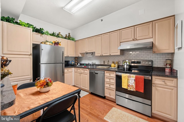 3100 N Leisure World Blvd Unit 716, Silver Spring, MD 20906 - kitchen featuring appliances with stainless steel finishes, under cabinet range hood, backsplash, light wood-type flooring, and dark countertops