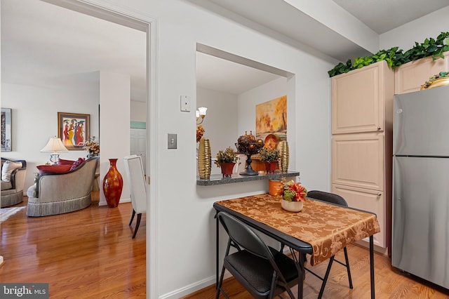 3100 N Leisure World Blvd Unit 716, Silver Spring, MD 20906 - kitchen with freestanding refrigerator, light wood-style floors, baseboards, and dark countertops