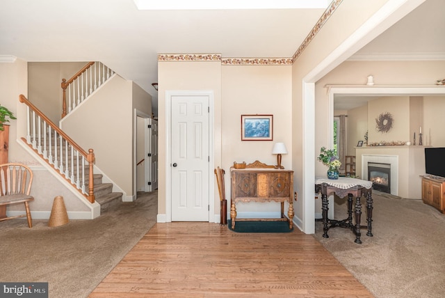 412 Hemlock Dr, New Cumberland, PA 17070 - carpeted foyer entrance with stairs, a glass covered fireplace, wood finished floors, ornamental molding, and baseboards