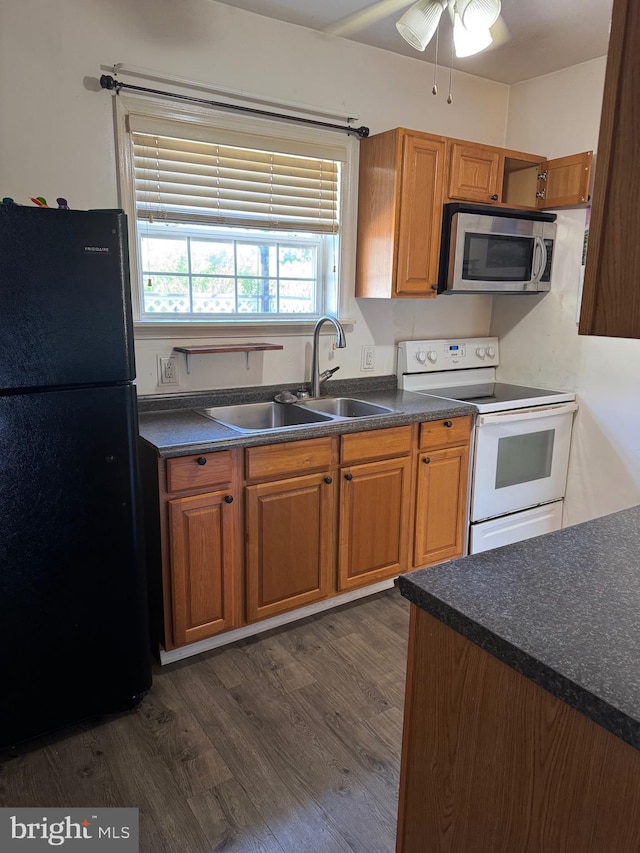 72 Maryland Ave, Crisfield, MD 21817 - kitchen with freestanding refrigerator, stainless steel microwave, white electric range, a sink, and dark countertops