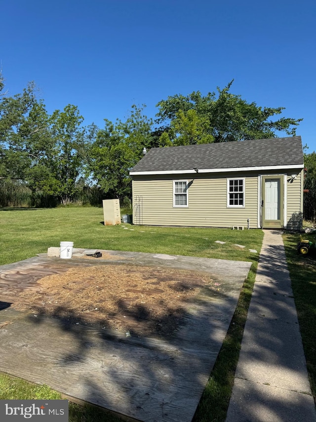 72 Maryland Ave, Crisfield, MD 21817 - view of front of house featuring a front lawn, an outbuilding, and roof with shingles