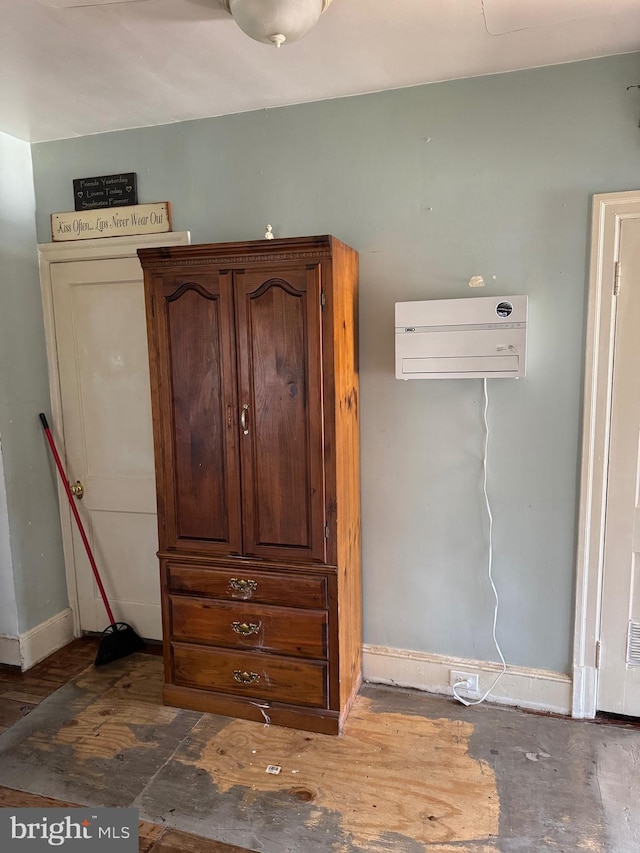 72 Maryland Ave, Crisfield, MD 21817 - detailed view of a wall unit AC, baseboards, and wood finished floors