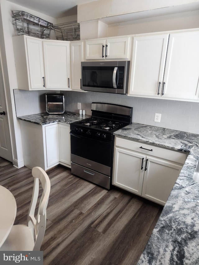 1337 Ward St, Baltimore, MD 21230 - kitchen with range with gas cooktop, stainless steel microwave, white cabinetry, dark wood-type flooring, and stone countertops