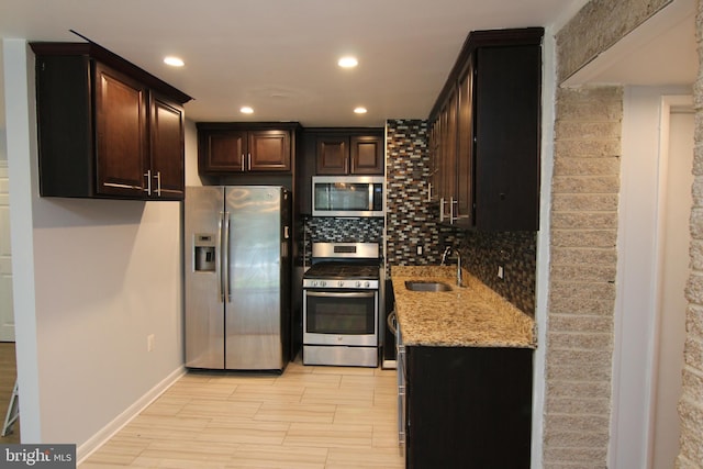 4415 Briarwood Ct N Unit 11, Annandale, VA 22003 - kitchen with stainless steel appliances, a sink, decorative backsplash, light stone counters, and light wood-style floors