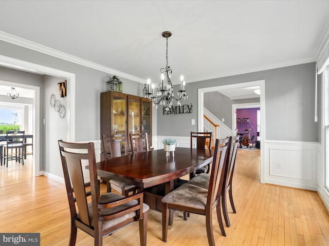 7100 Ewing Ct, Middletown, MD 21769 - dining space with a chandelier, light wood-style flooring, a wainscoted wall, ornamental molding, and stairway