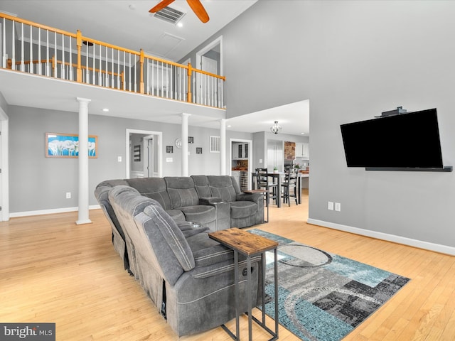 7100 Ewing Ct, Middletown, MD 21769 - living area with ornate columns, a towering ceiling, hardwood / wood-style floors, and ceiling fan