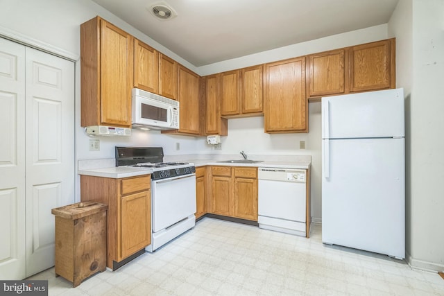 22 Regents Ct, Bensalem, PA 19020 - kitchen featuring white appliances, light countertops, light flooring, a sink, and brown cabinets