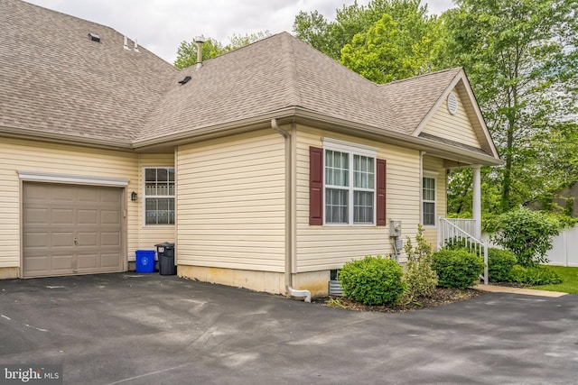 22 Regents Ct, Bensalem, PA 19020 - view of home's exterior featuring a shingled roof, driveway, and a garage